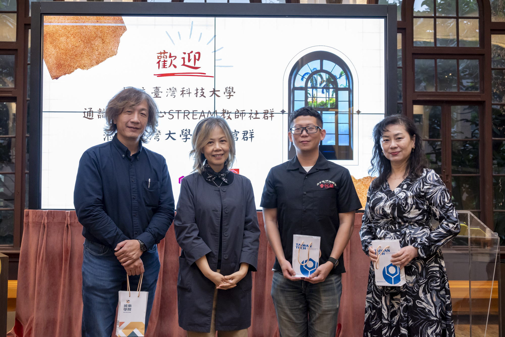 通識中心李思穎主任(左二)致贈臺科城南學院紀念品，並與臺大胡哲明教授(左一)、臺大校史館張安明組長(右一)、臺大校史館吳鑫餘行政專員(右二)合影